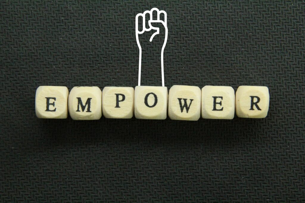 the word empower on a wooden cube with hands up